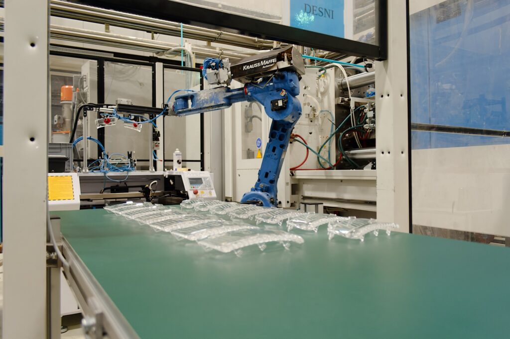 Robotska roka premika transparente plastične izdelke